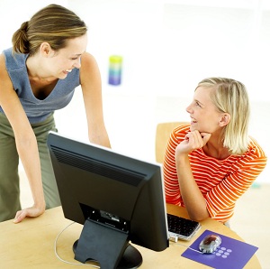 Two Young Women in Front of the Computer Talking